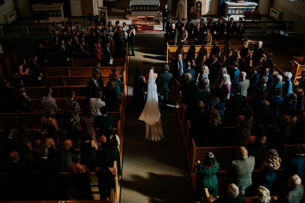 The bride walking down the aisle from behind