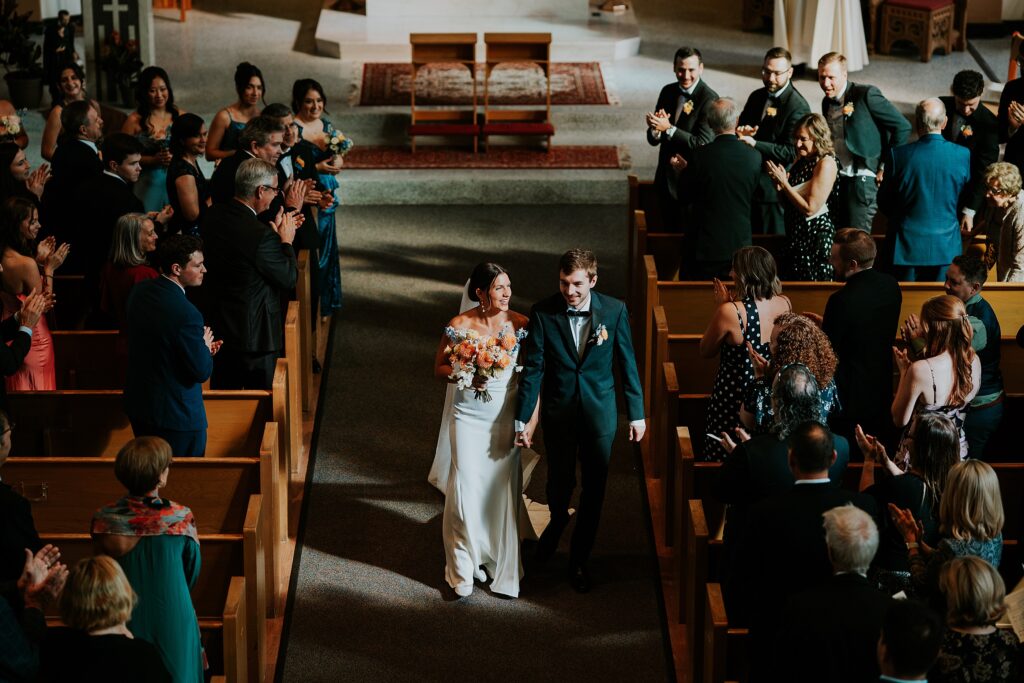 Bride and groom walking back down the aisle as a married couple