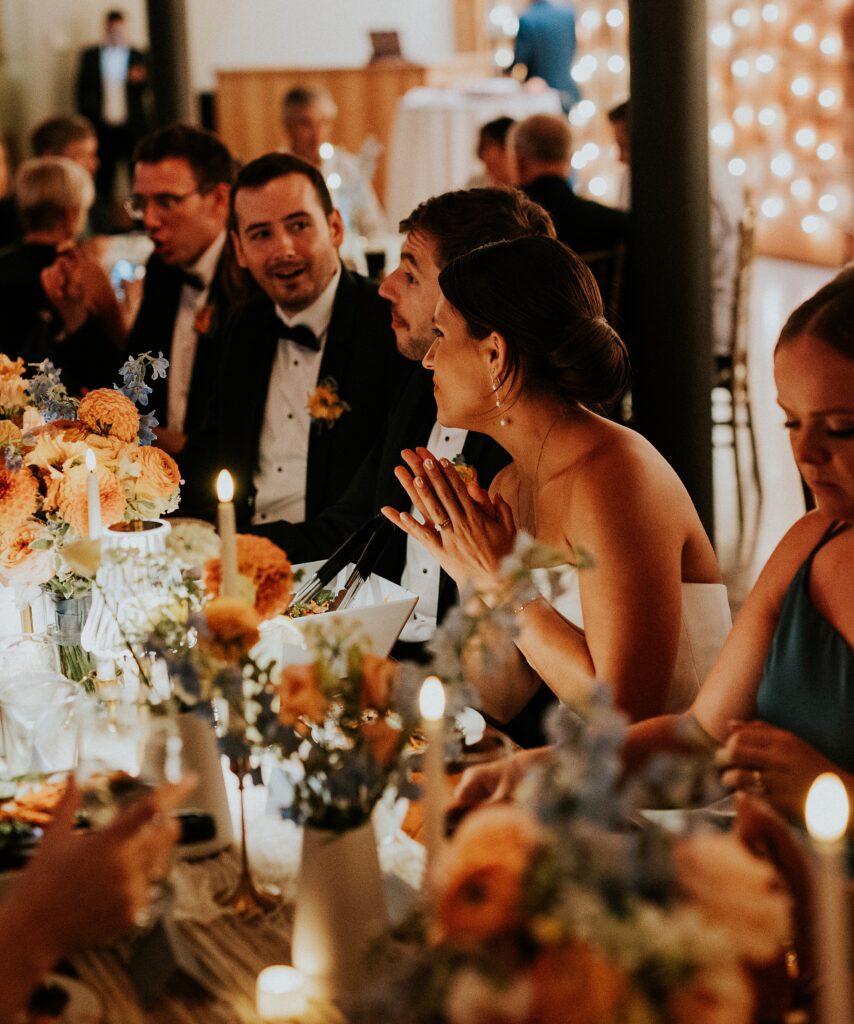 The couple enjoying dinner on their wedding day, lit by candlelight