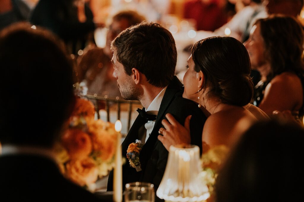 Bride and groom supporting each other with a hug during emotional speeches
